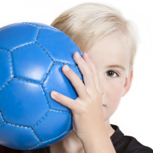 child standing behind soccer ball