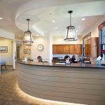 Three staff members working at the front desk